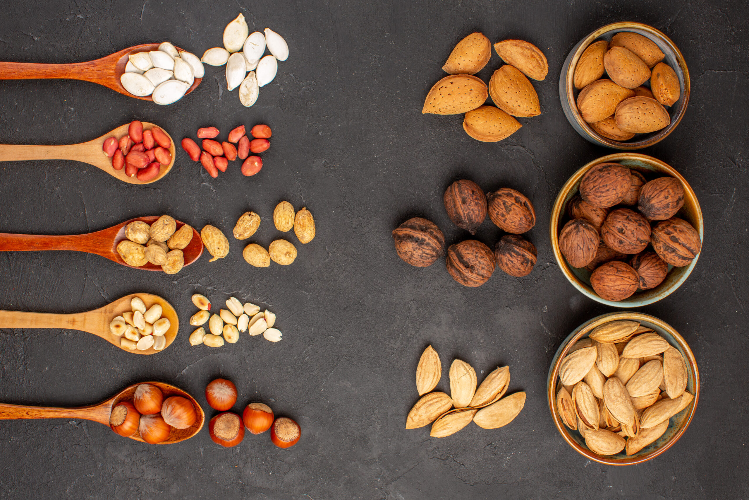 top-view-fresh-nuts-peanuts-other-nuts-dark-surface